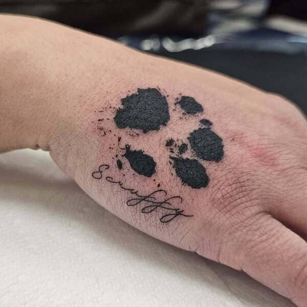 62 Beautiful Remembrance Tattoos for Dogs: A Heartfelt Tribute 37 Realistic dog paw print memorial tattoo with custom script on hand, black ink style