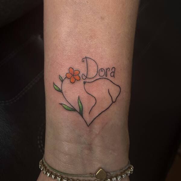 62 Beautiful Remembrance Tattoos for Dogs: A Heartfelt Tribute 29 Heart-shaped dog silhouette with name 'Dora' and orange flower memorial tattoo