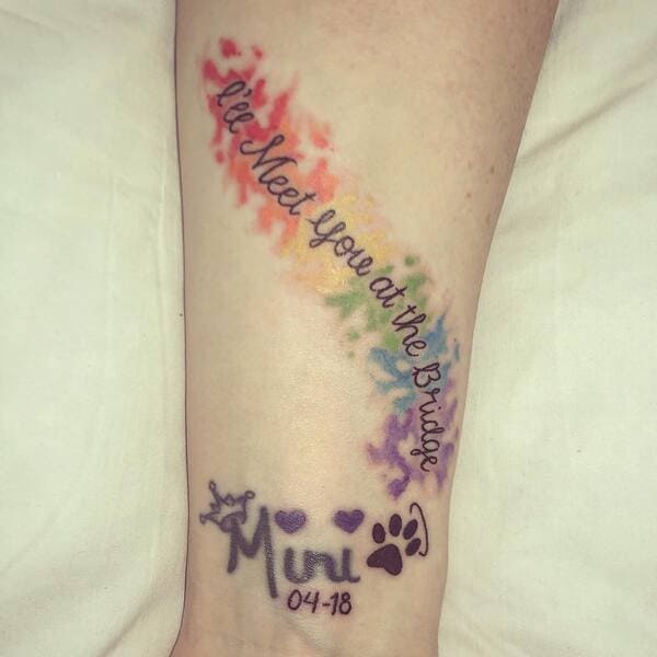 62 Beautiful Remembrance Tattoos for Dogs: A Heartfelt Tribute 55 Rainbow watercolor memorial tattoo with 'Mini' name and date, rainbow bridge quote