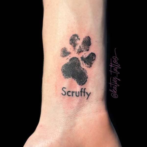 62 Beautiful Remembrance Tattoos for Dogs: A Heartfelt Tribute 42 Realistic black paw print memorial tattoo with name Scruffy on wrist